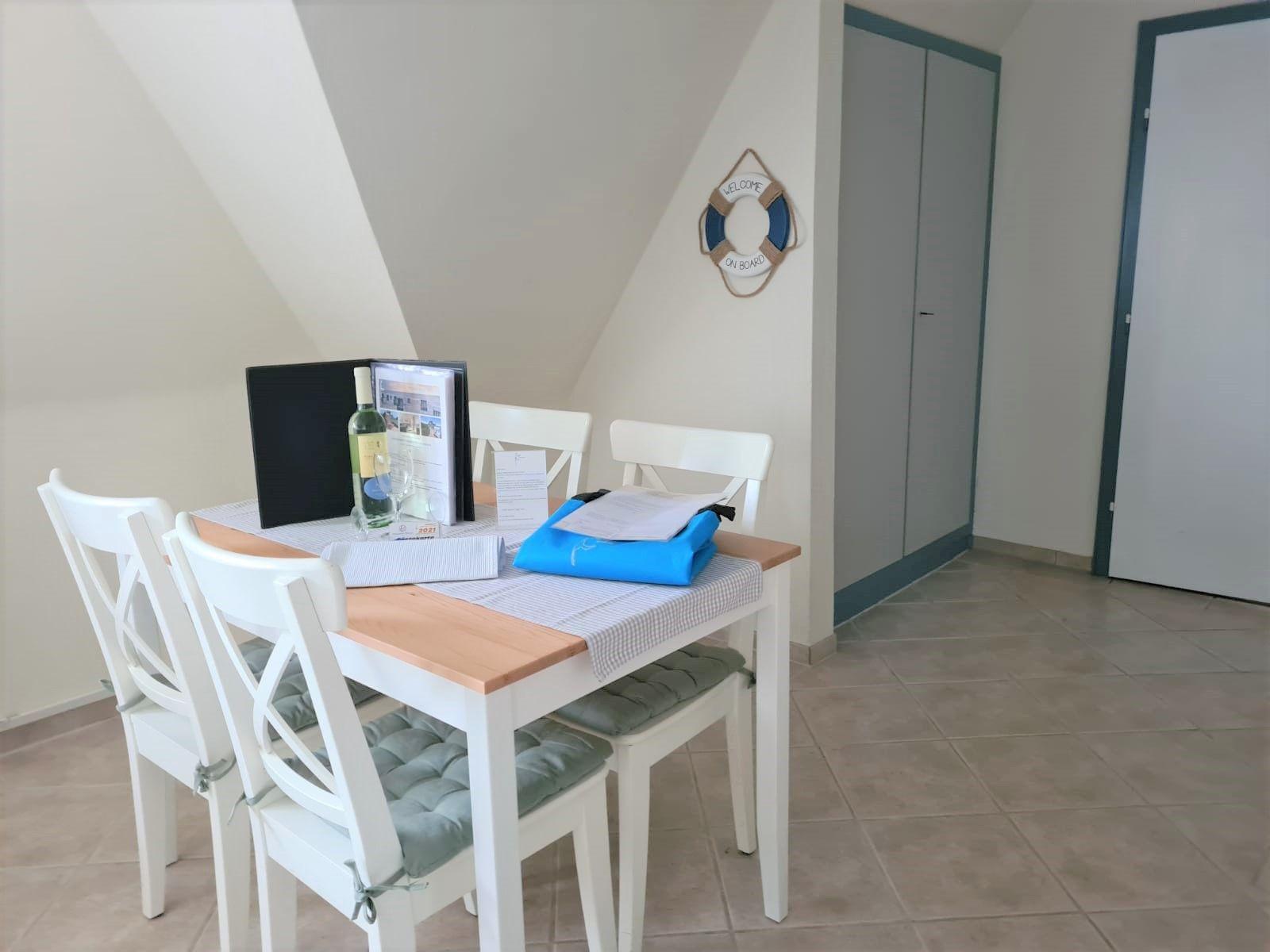 Essbereich mit Tisch, Stühlen und dekorativen Gegenständen an der Wand.