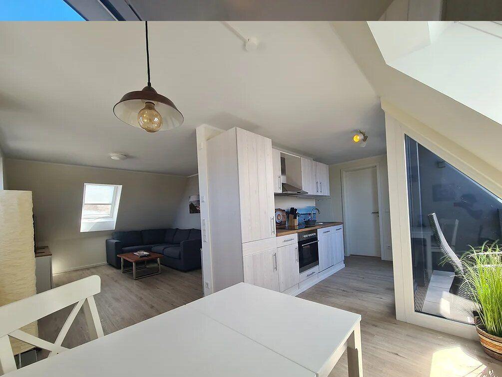 Living kitchen with dining area, bedroom and windows