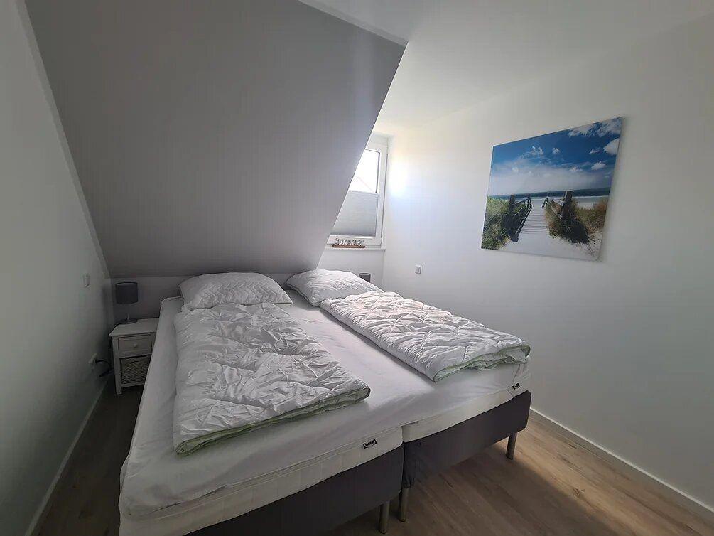 Bedroom with double bed, window, and wall picture.