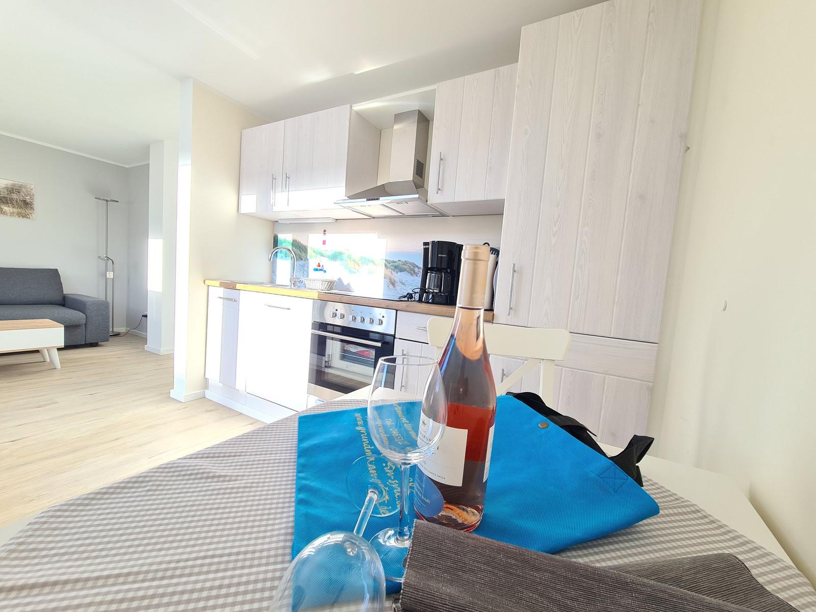 Küche mit Essbereich und Wohnzimmer im Hintergrund.