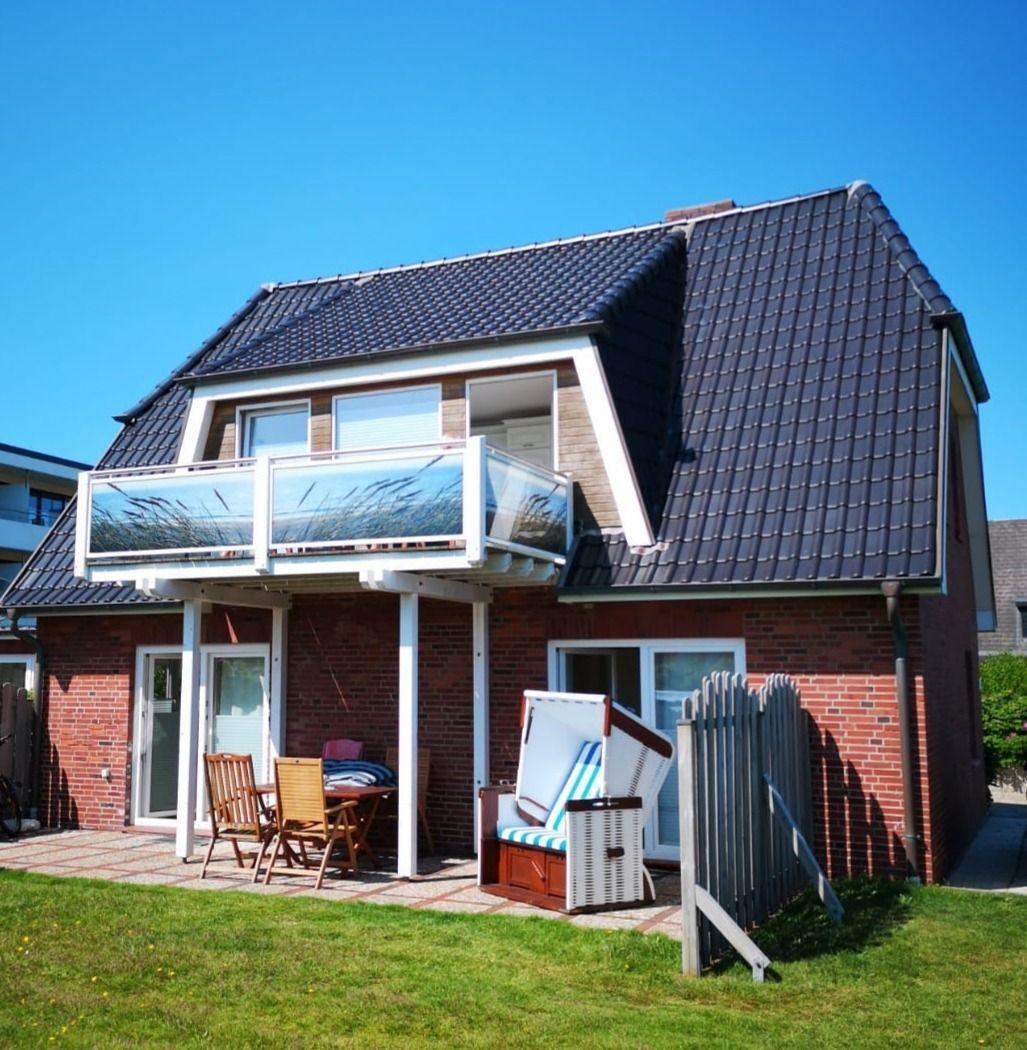 Zwei-Schichten-Haus mit Balkon, Terrasse und Strandkorb.