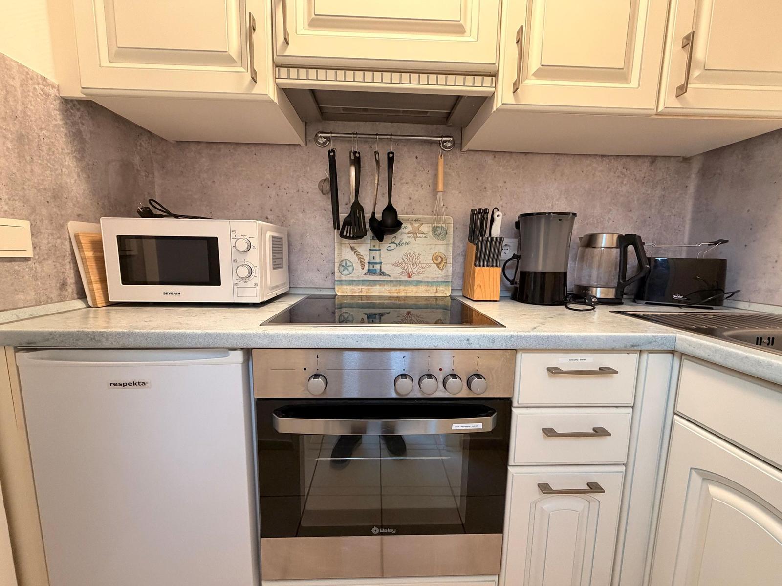 Kitchen with stove, microwave, and countertop.