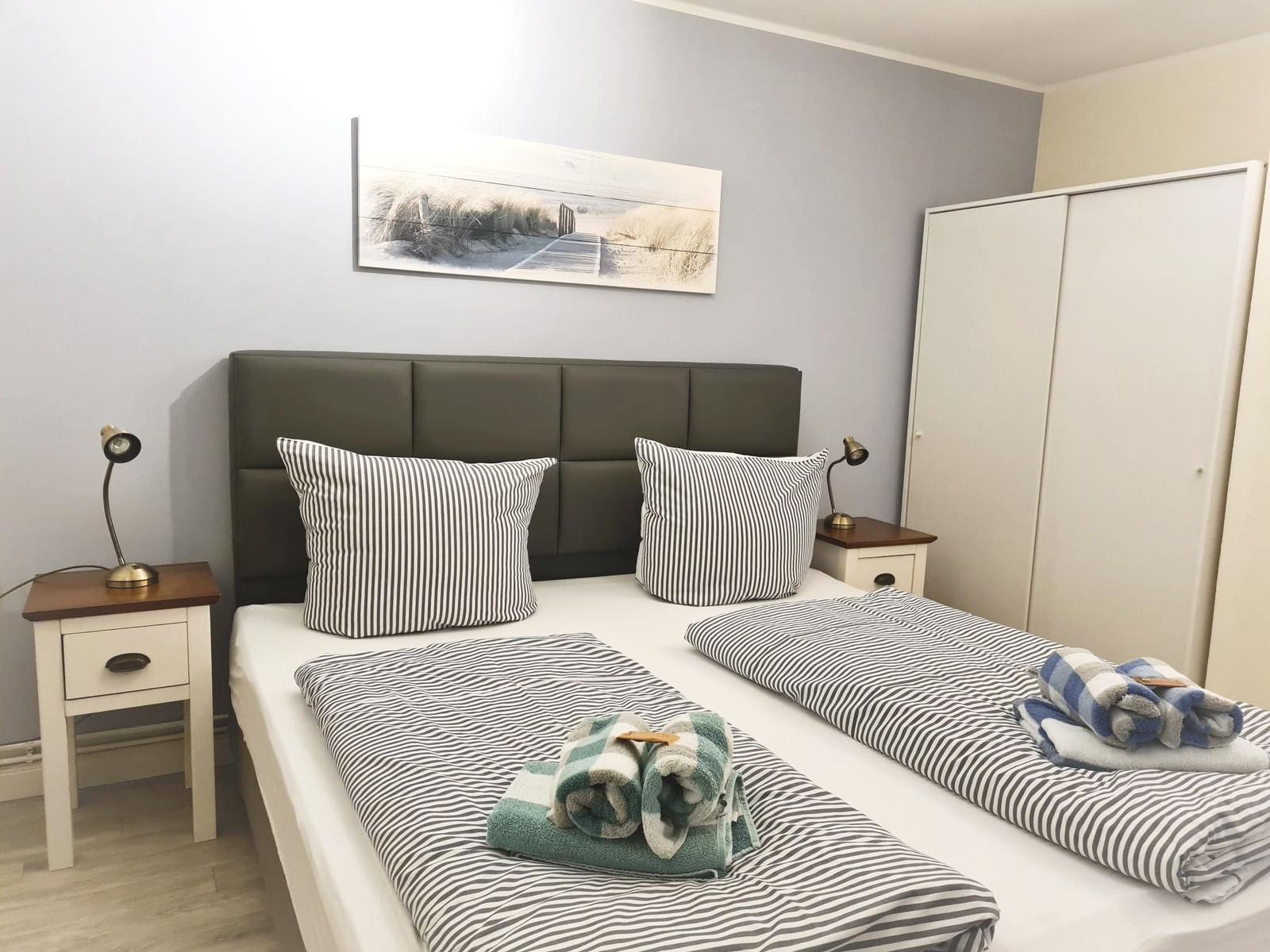 Bedroom with double bed, two nightstands, and wardrobe.
