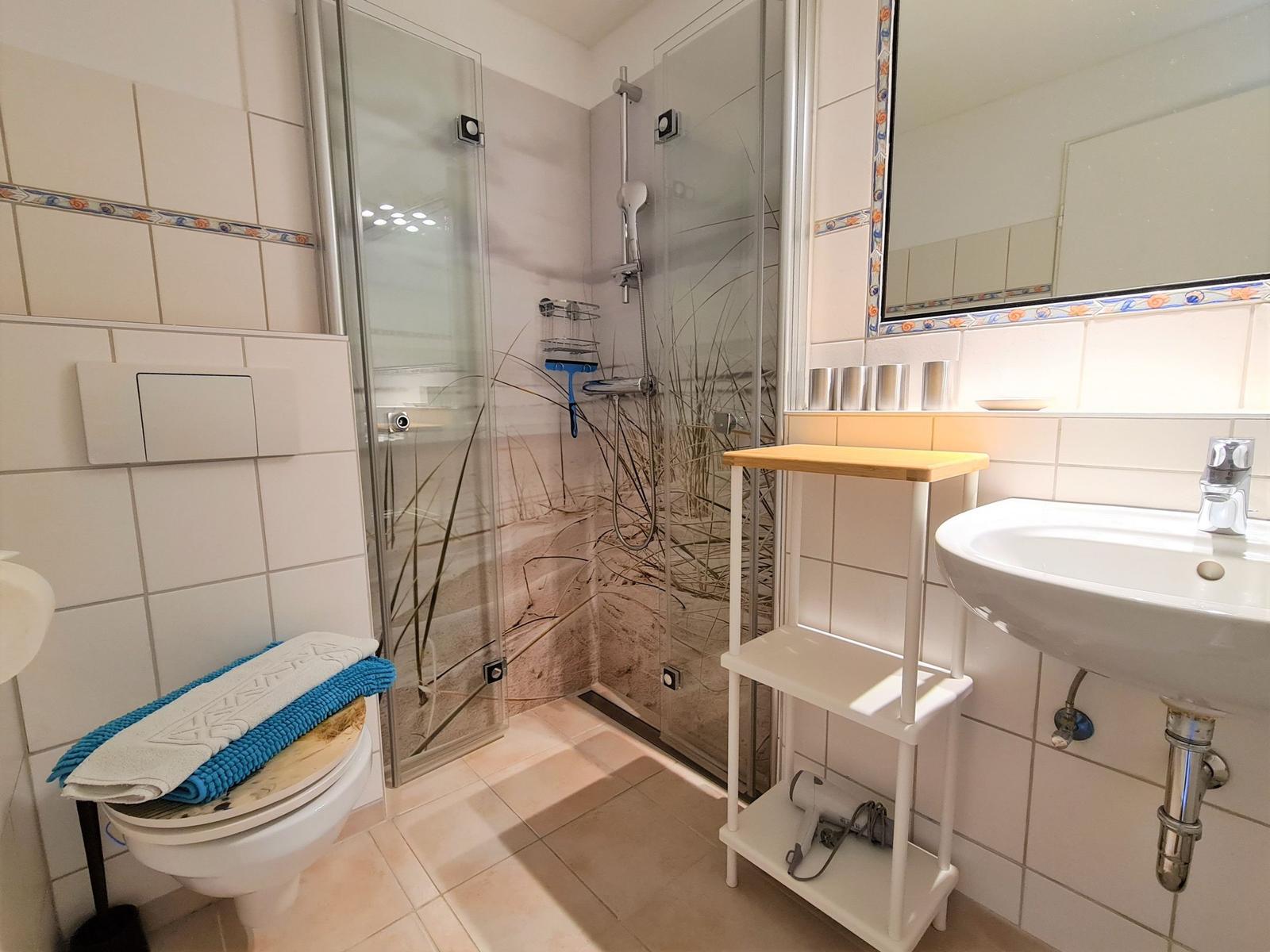 Bathroom with shower, sink, and toilet.