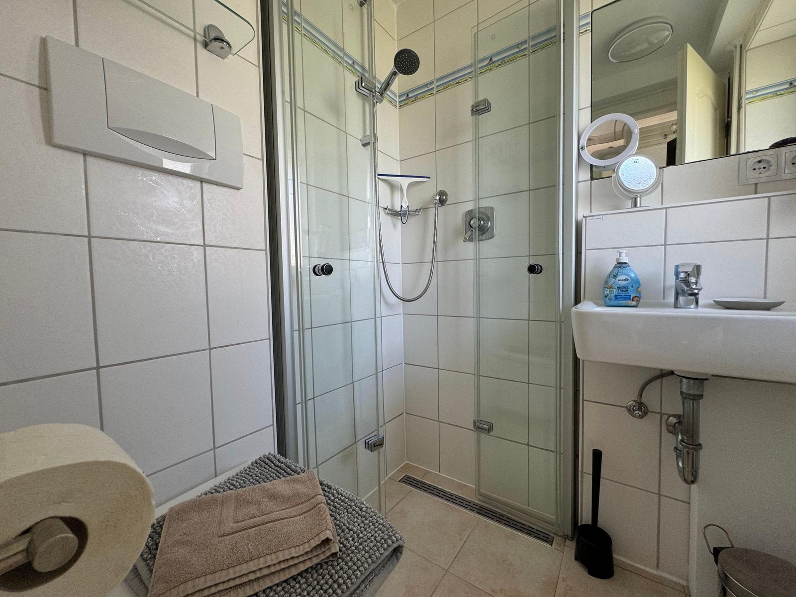 Bathroom with shower, sink, and toilet.