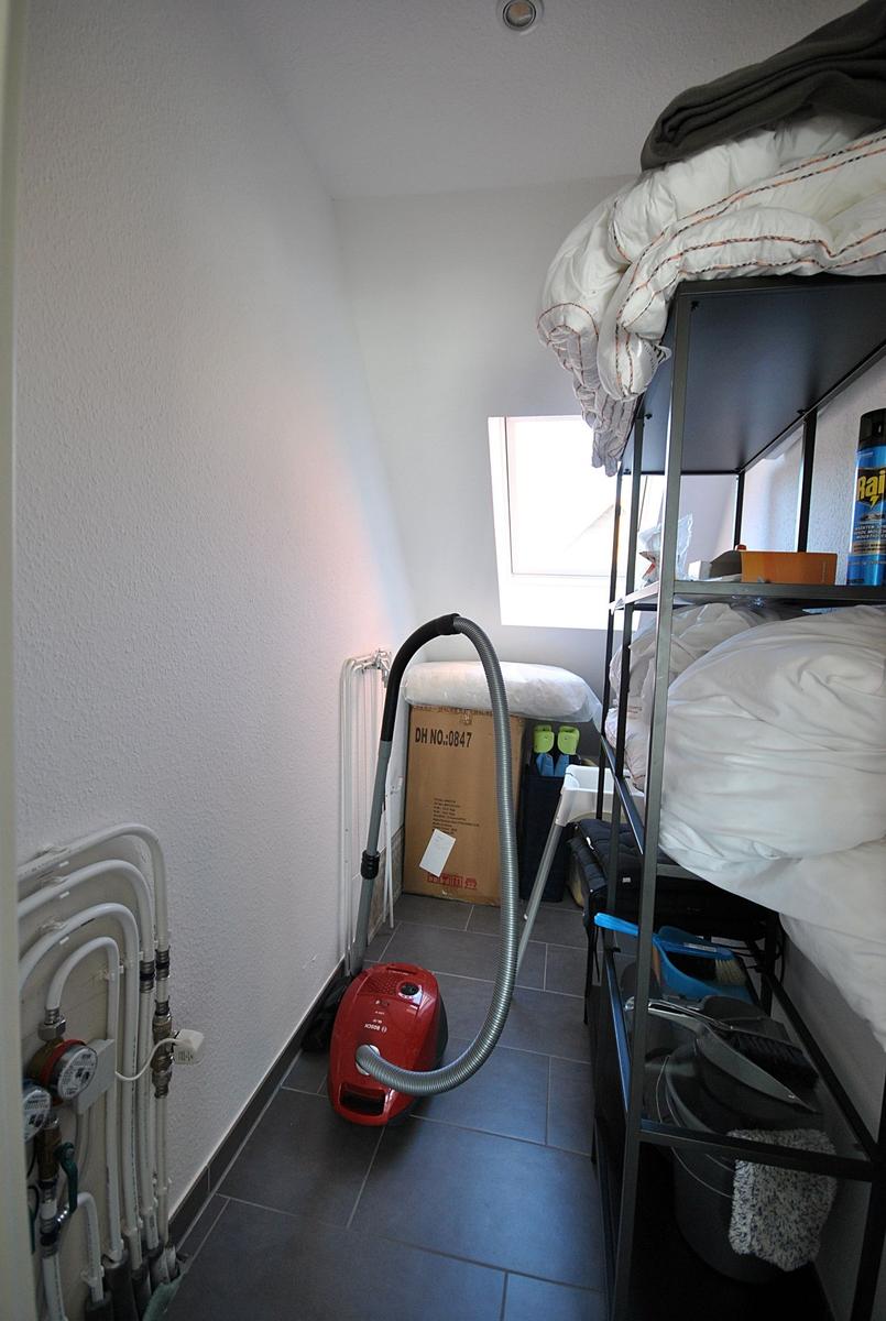 Schlafzimmer mit Hochbett, Staubsauger und Fenster.
