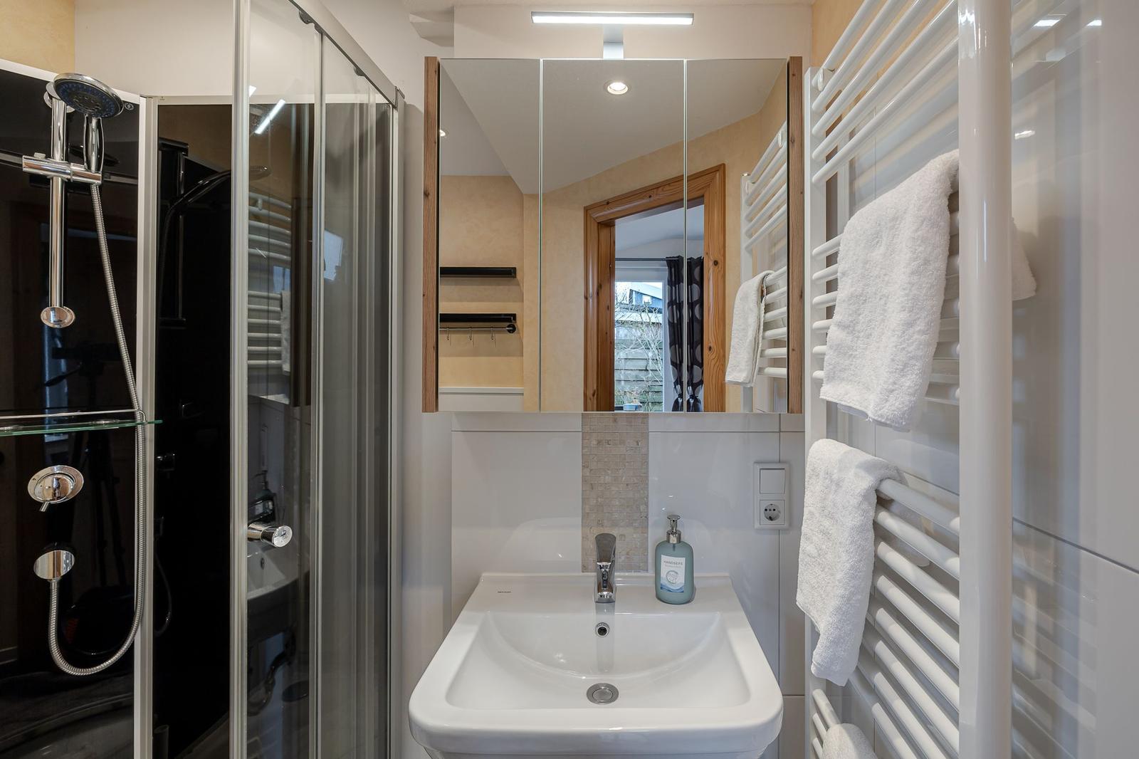 Bad mit Dusche, Waschbecken und Handtuchheizung