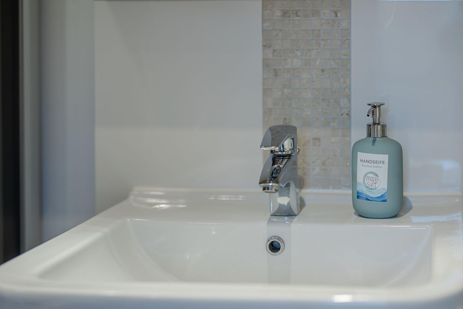 Waschbecken mit Wasserhahn und Seifenspender