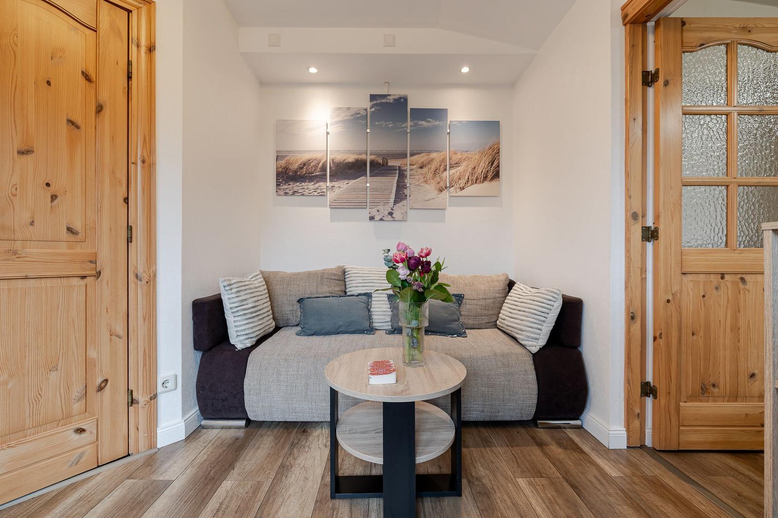 Wohnzimmer mit Sofa, Tisch und Wandbild