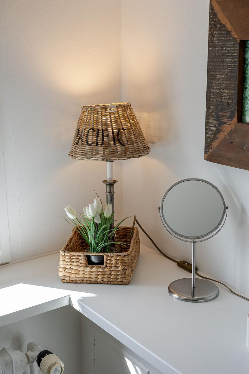 Table lamp with basket and mirror on white counter
