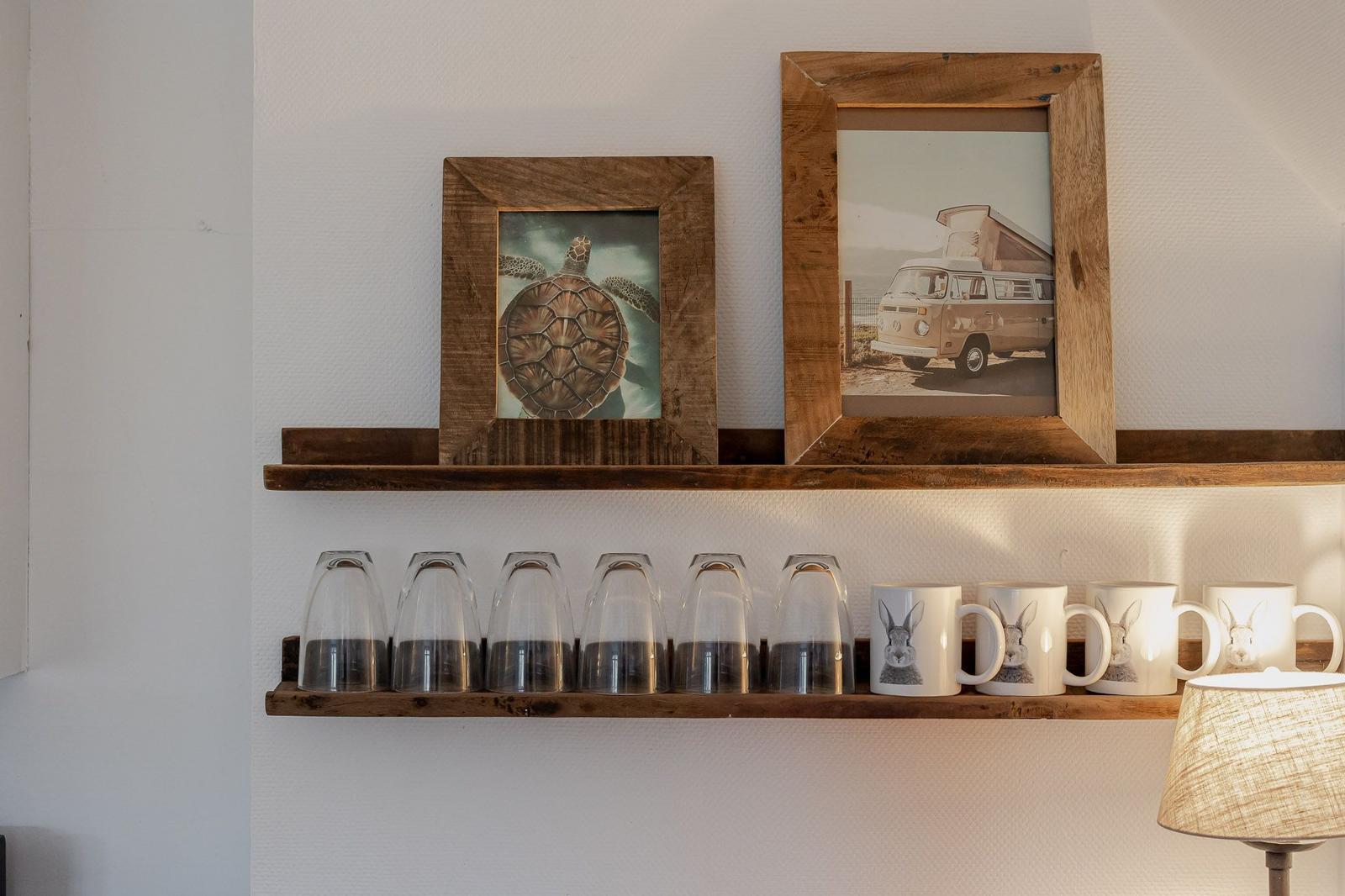 Wall shelf with pictures, glasses, and mugs with rabbit motif.