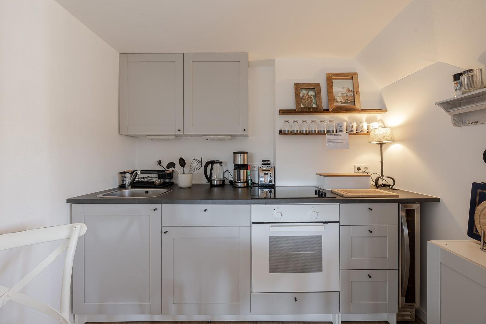 Kitchen with white cabinets, stove, and worktop.