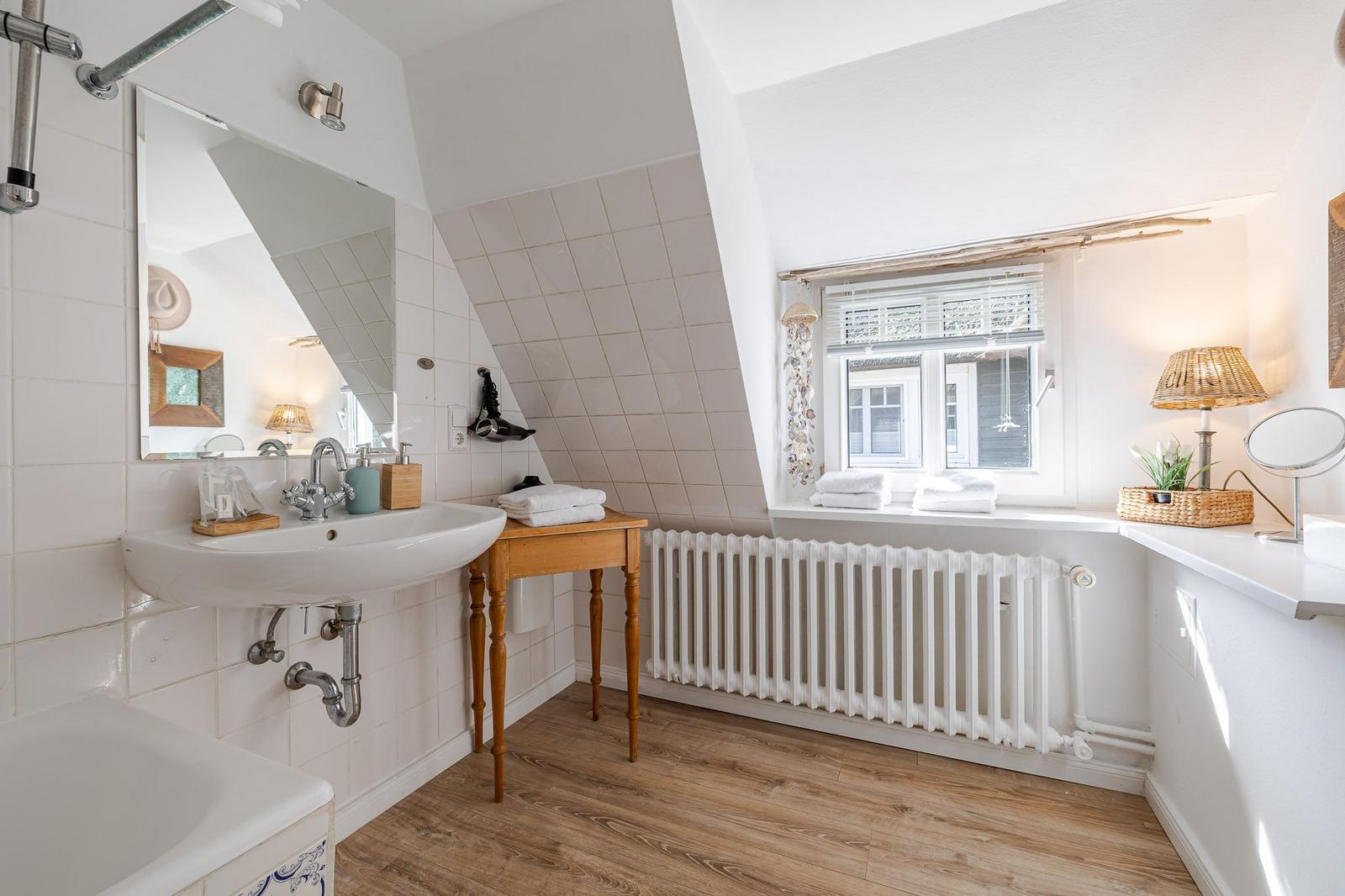 Bathroom with shower, sink, and window