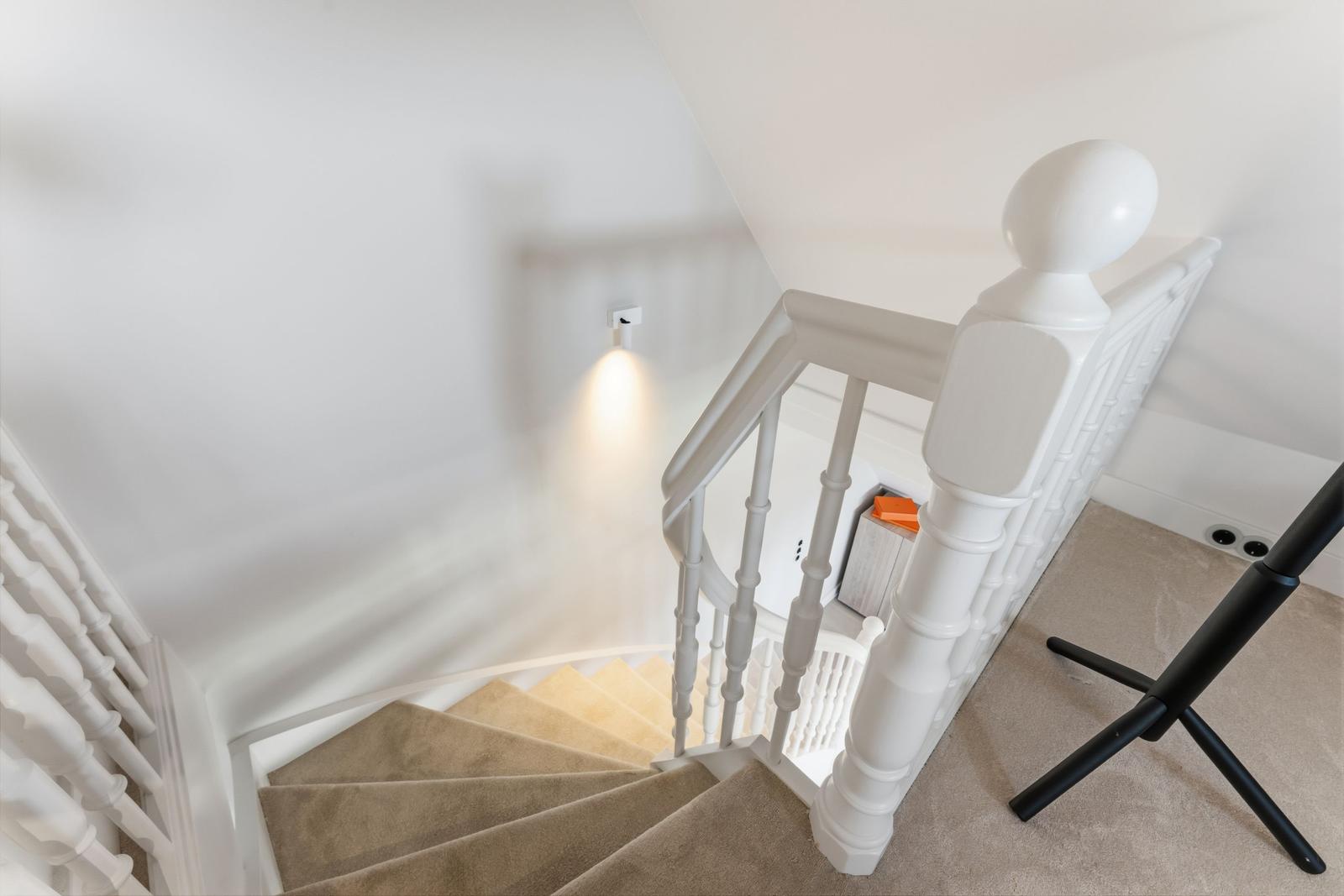 Weiße Treppe mit Teppich und Geländer im Haus