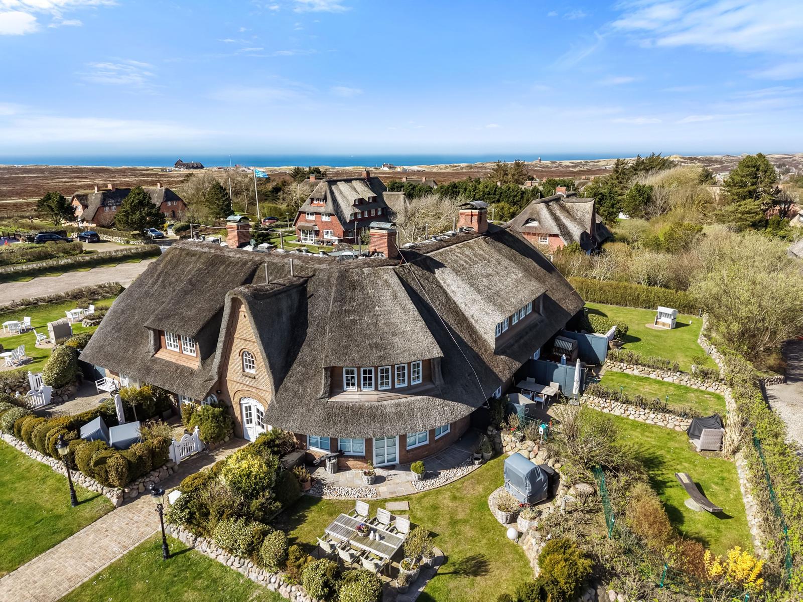 Dorfhaus mit Strohdach, Garten und Meerblick.