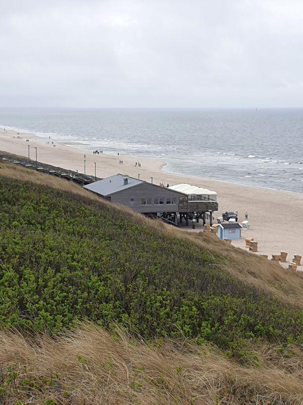 Haus auf Stelzen am Strand mit Blick aufs Meer