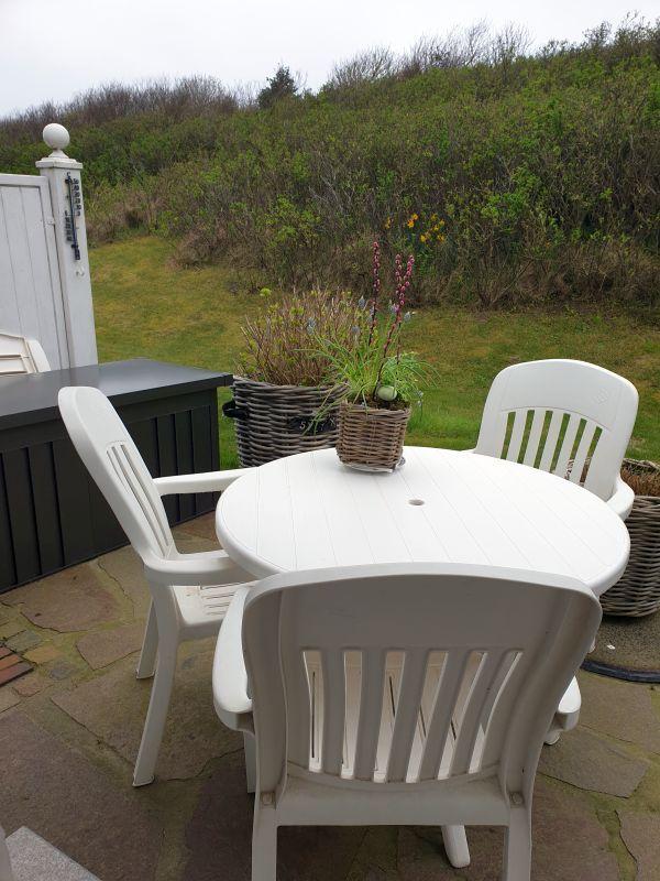 Runder Tisch mit Stühlen und Pflanzen auf Terrasse