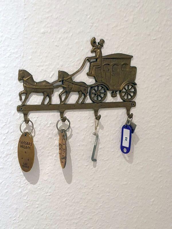 Schlüsselhalter mit Kutsche, an dem Schlüssel hängen.