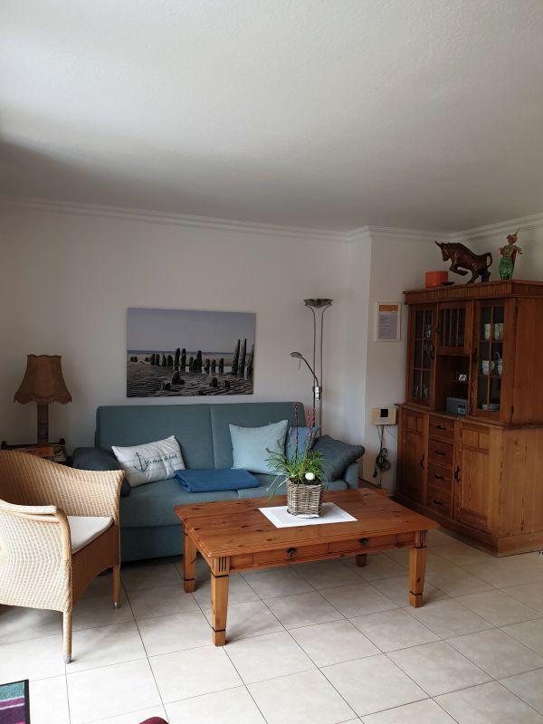 Wohnzimmer mit Sofa, Holztisch und Sideboard.
