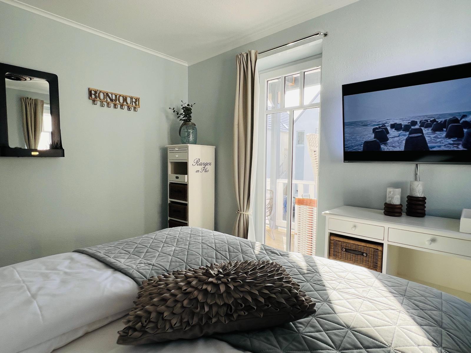 Hauptschlafzimmer mit direktem Zugang zum West-Teakholzbalkon mit Strandkorb und Teakholzmöbel.