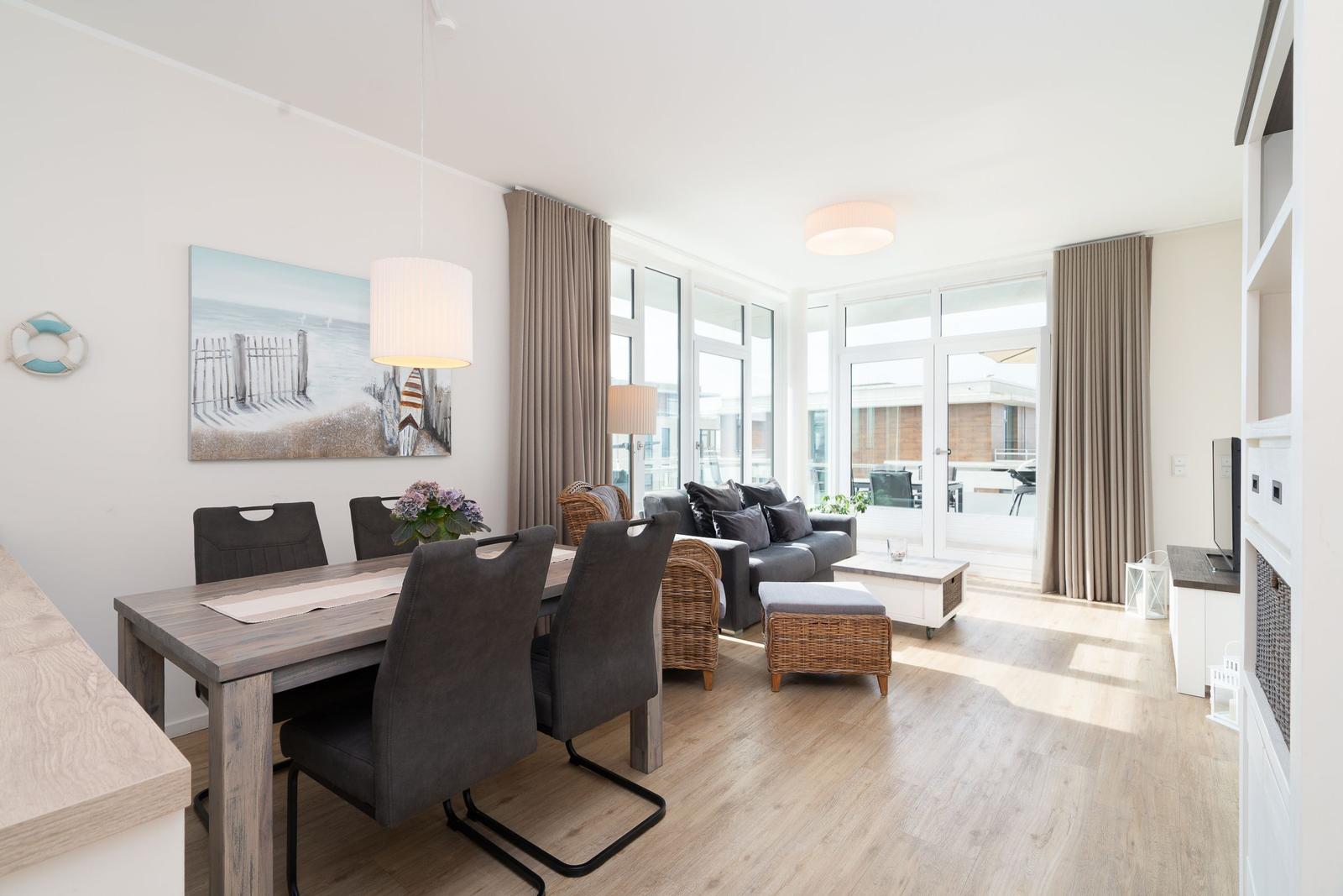 Wohn- und Essbereich mit Sofa, Esstisch und Blick auf Balkon.