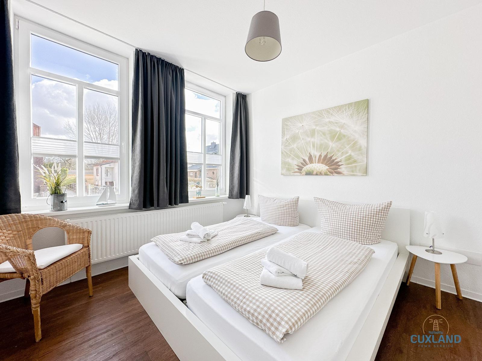 Zimmer mit Doppelbett, Fenster und Wandbild