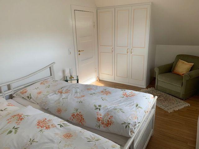 Bedroom with double bed, wardrobe, and armchair.