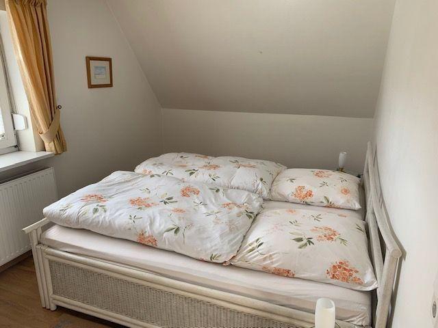 Bedroom with double bed, window, and sloped ceiling.