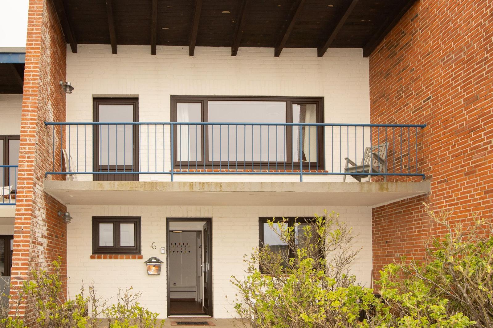 Two-story house with balcony, entrance, and windows