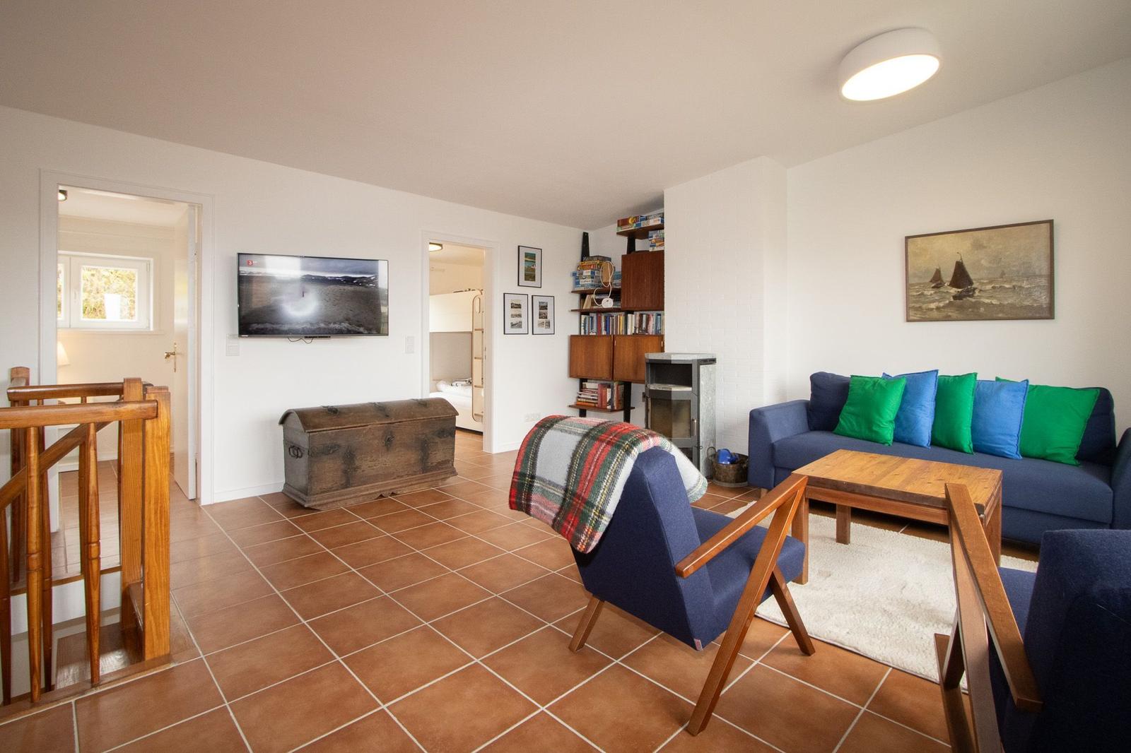 Living room with sofa, TV, and wooden furniture.