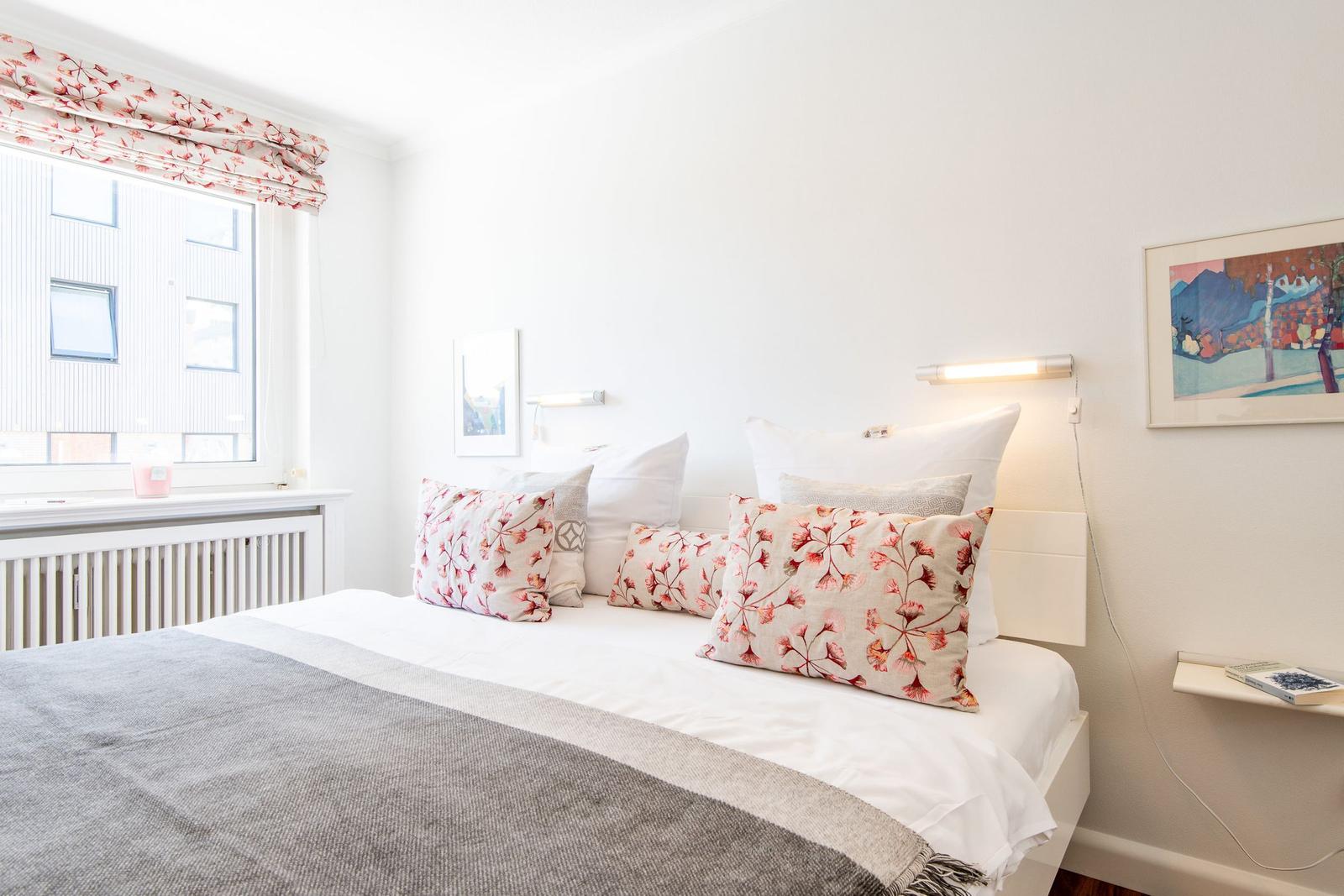 Bedroom with bed, window, and wall art.