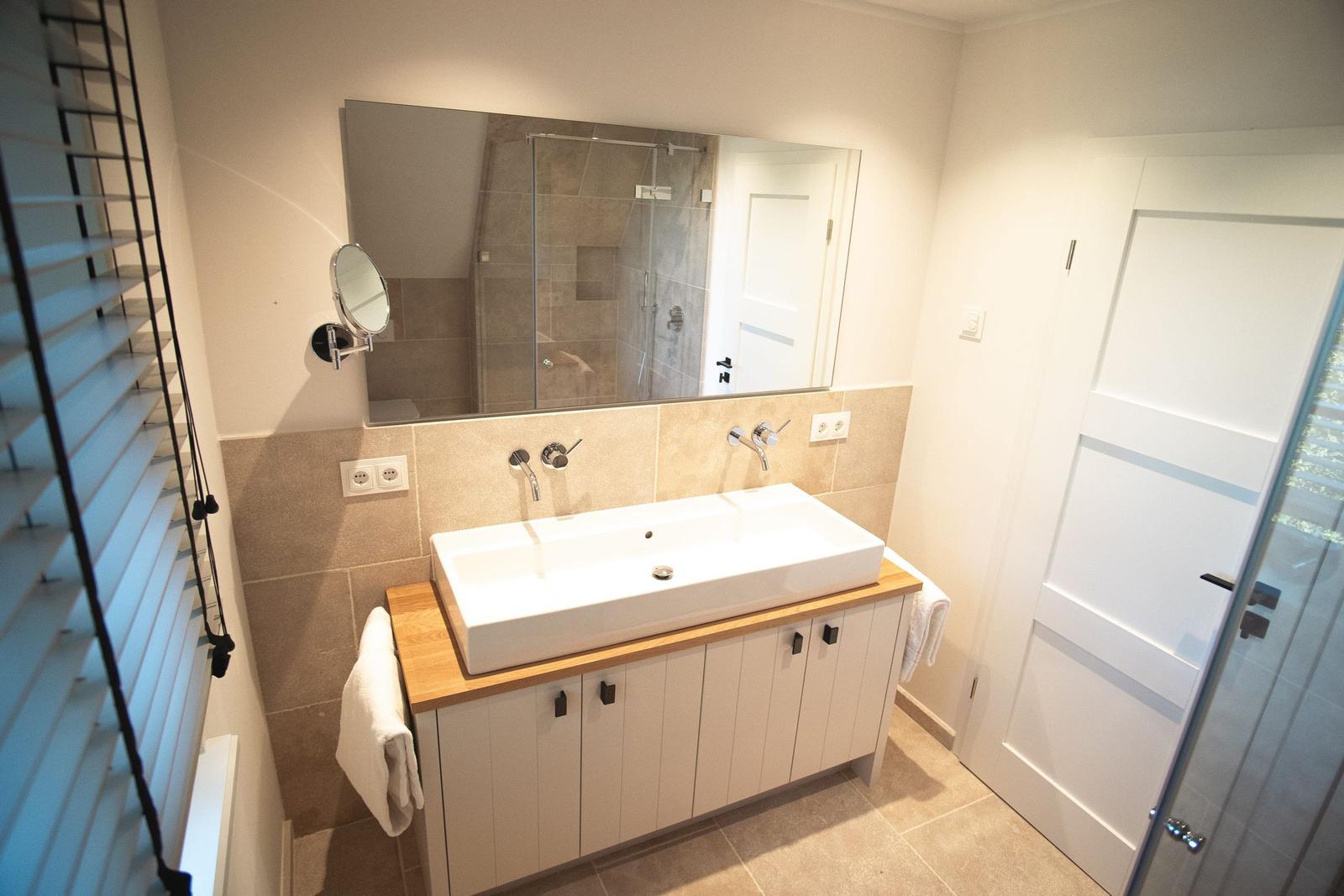 Bad mit Waschbecken, Spiegel und Dusche