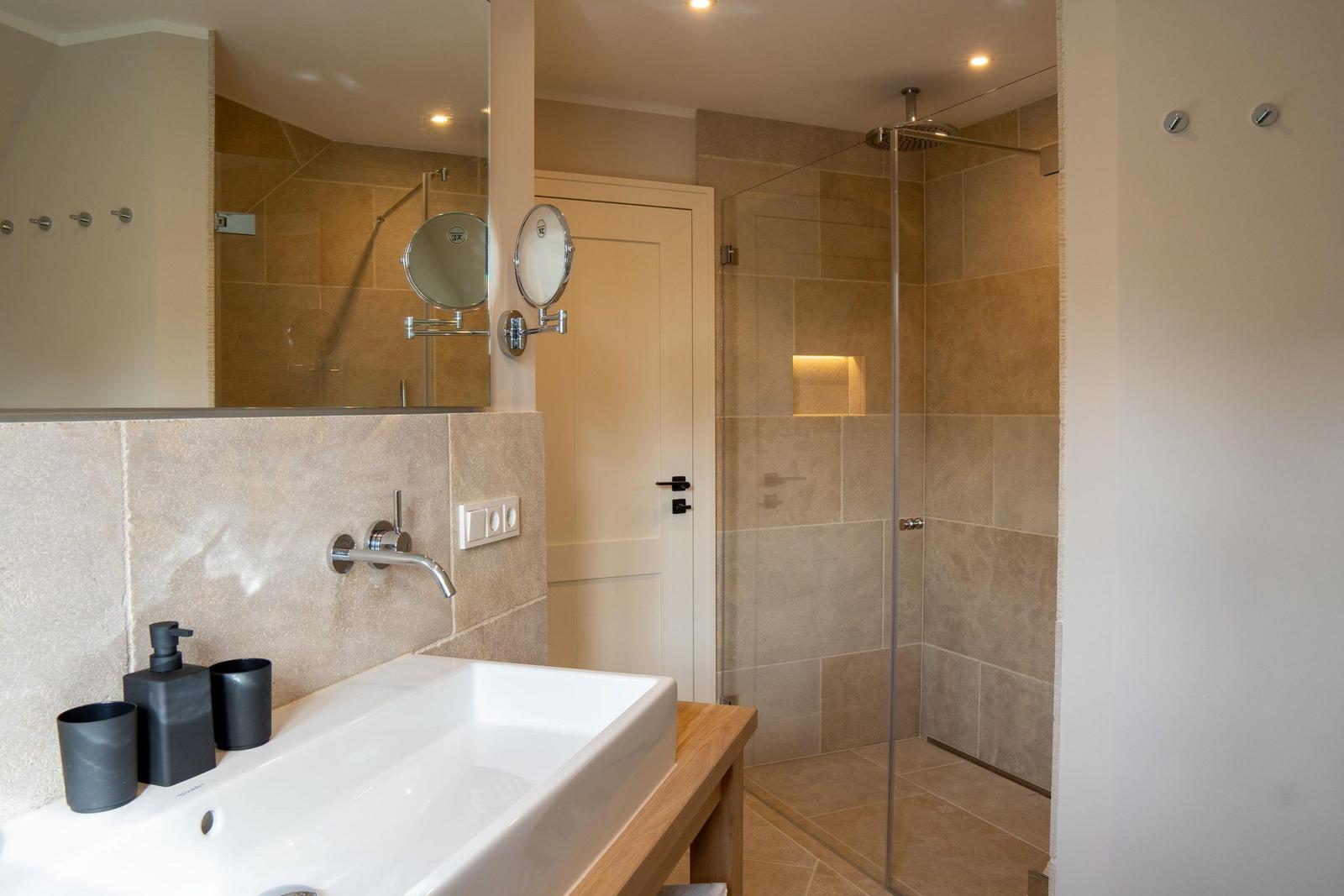 Bad mit Dusche, Waschbecken und Spiegel