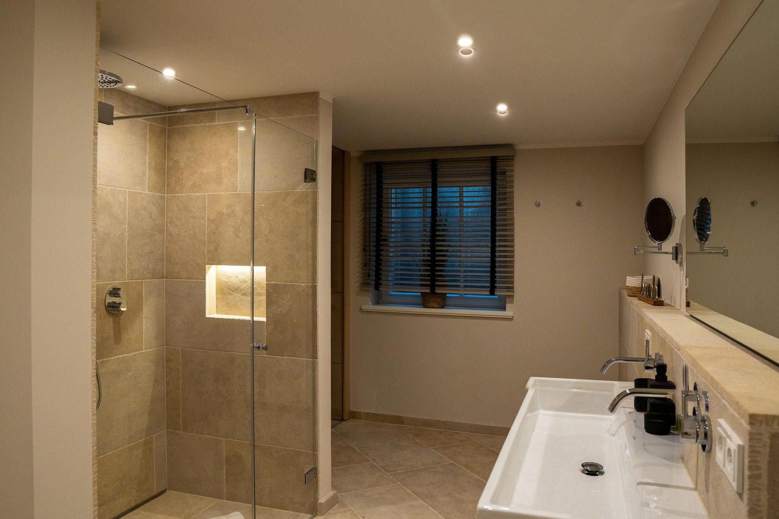 Bad mit Dusche, Waschbecken und Fenster mit Jalousie