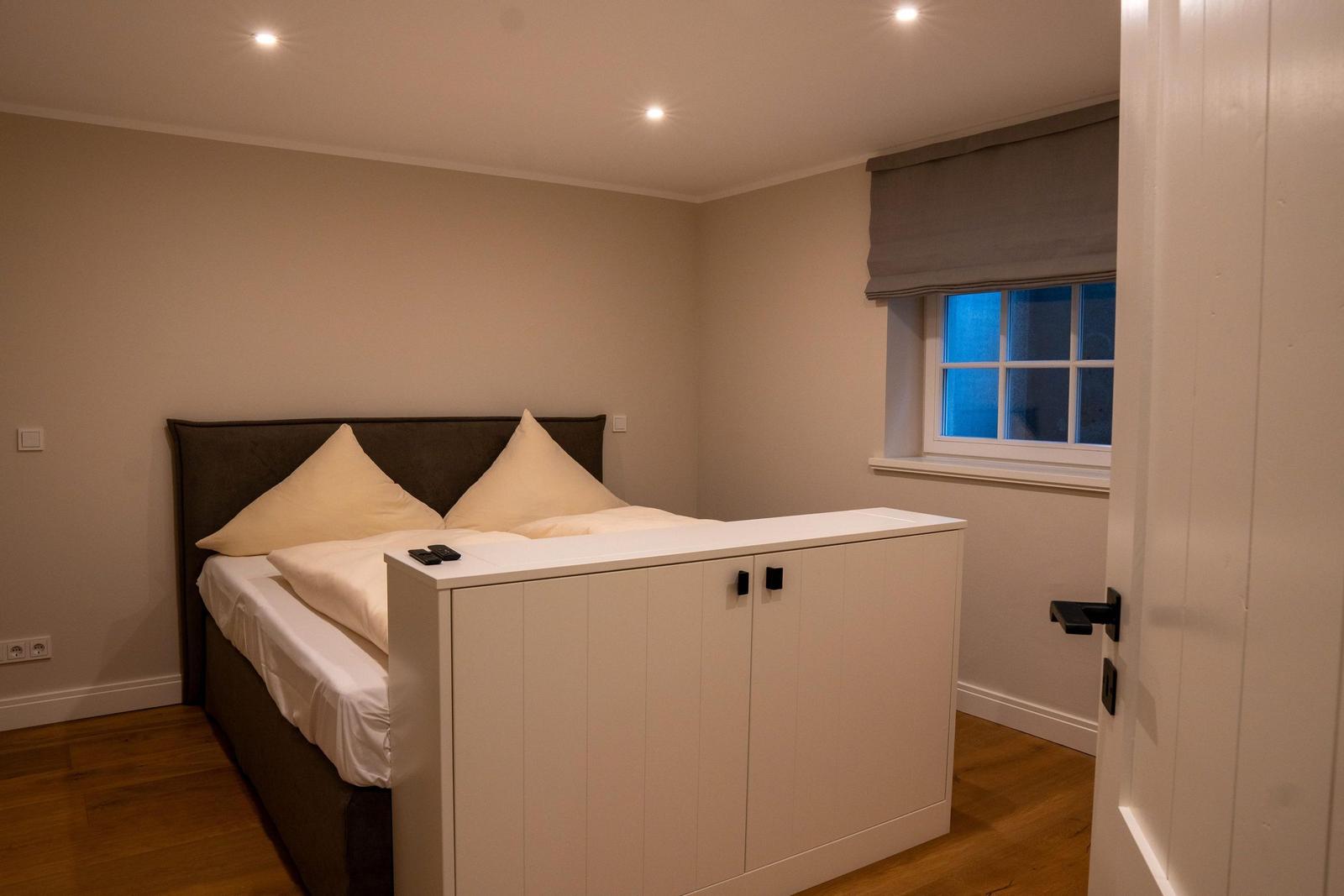 Schlafzimmer mit Bett, Schrank und Fenster