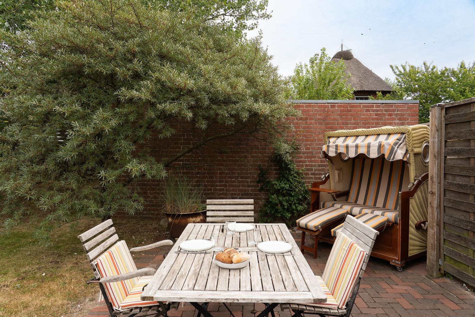 Hinterhof mit Tisch, Stühlen und Strandkorb. Hinterhof mit Tisch, Stühlen und Strandkorb.