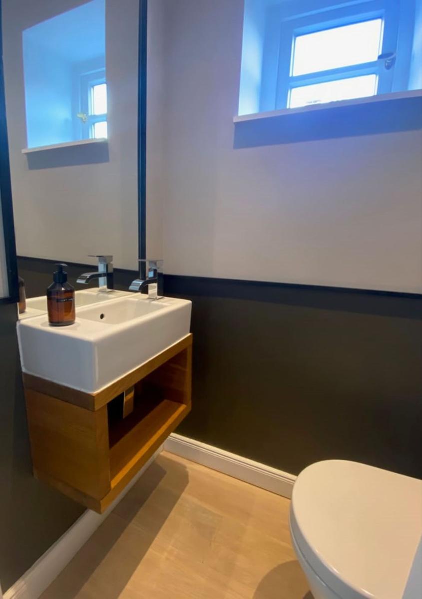 Badezimmer mit Waschbecken, Spiegel und Toilette