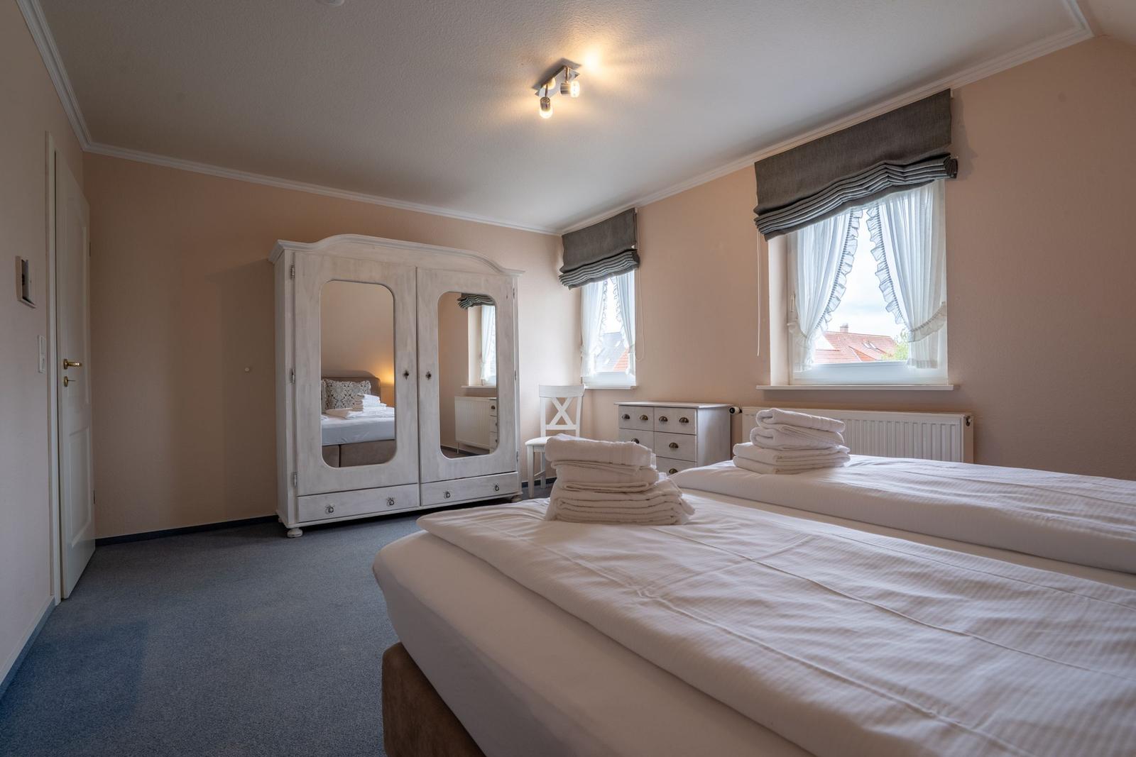 Zimmer mit zwei Betten, Kleiderschrank und Fenster mit Blick.