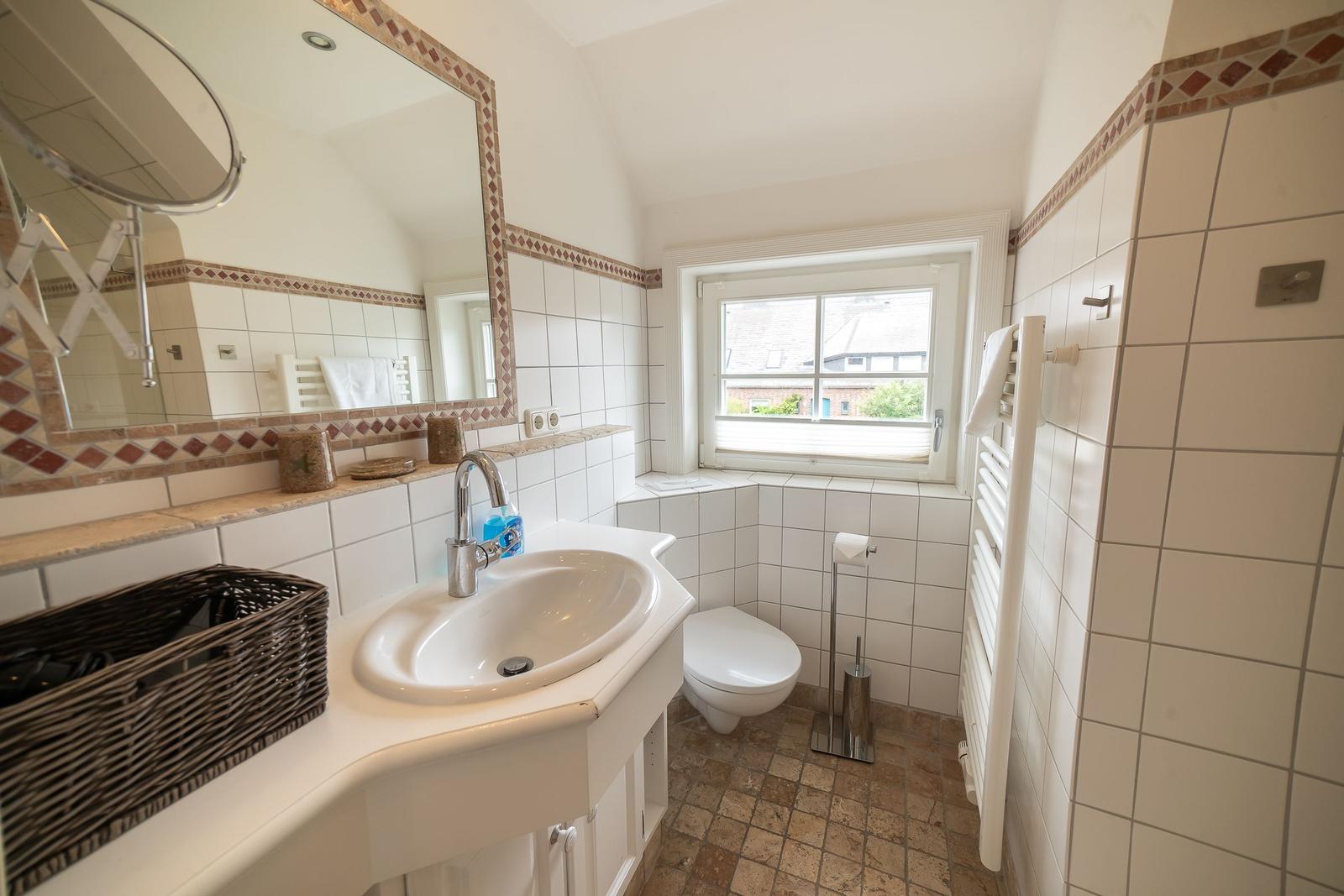 Bathroom with sink, toilet, and window