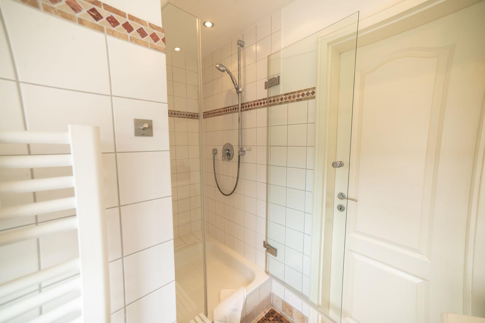 Bathroom with shower, bathtub, and heater
