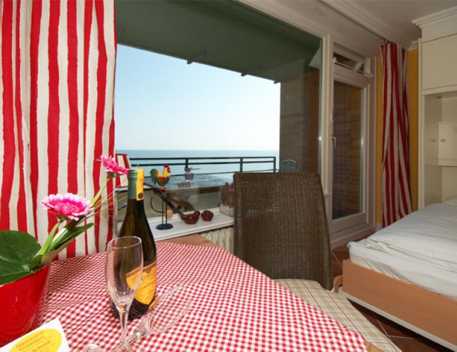 Tisch mit Tischdecke, Weinflasche und Blick aufs Meer