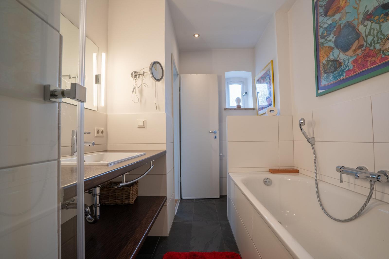 Bathroom with bathtub, sink, and mirror