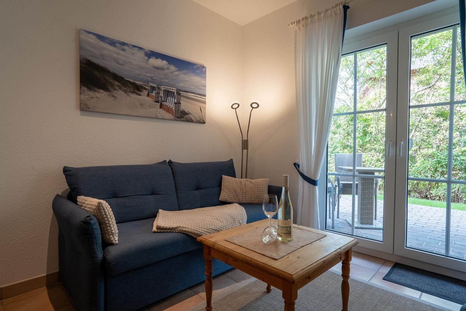 Living room with sofa, table, and view to the terrace.