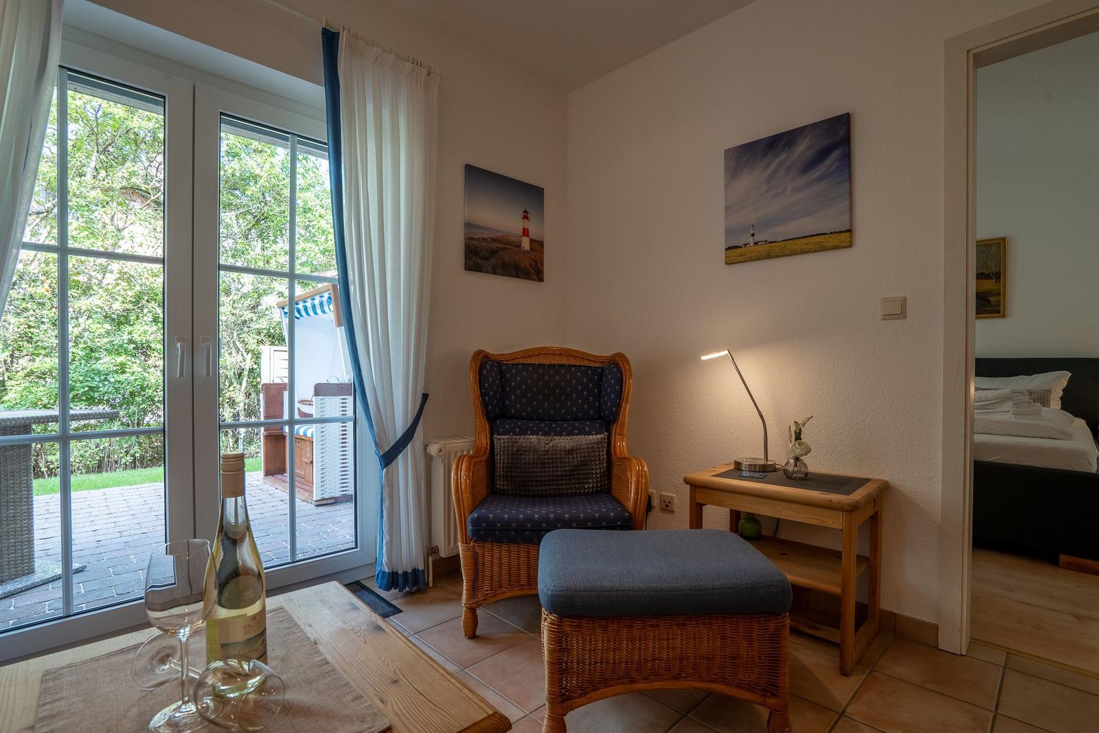 Living area with armchair, table, and view of terrace