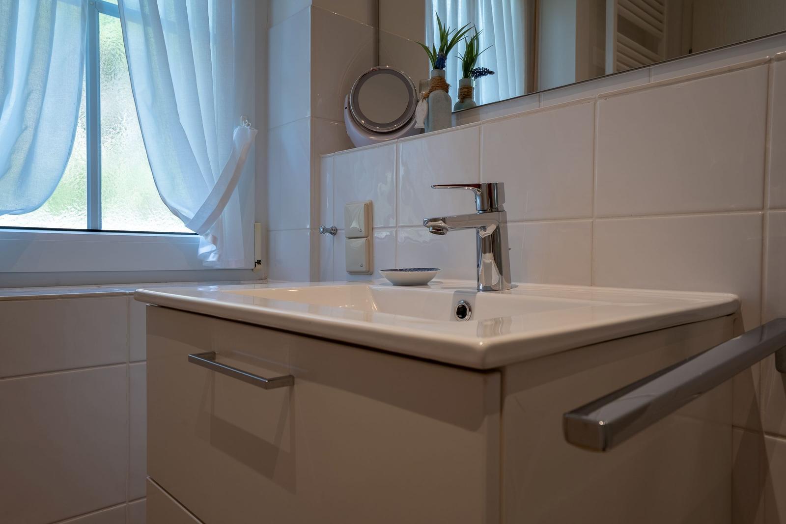Sink with mirror and window in bathroom