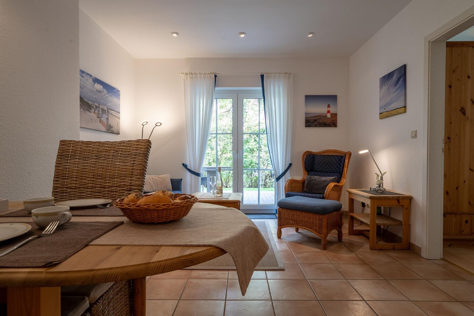 Dining area with table, chairs, and view of balcony.