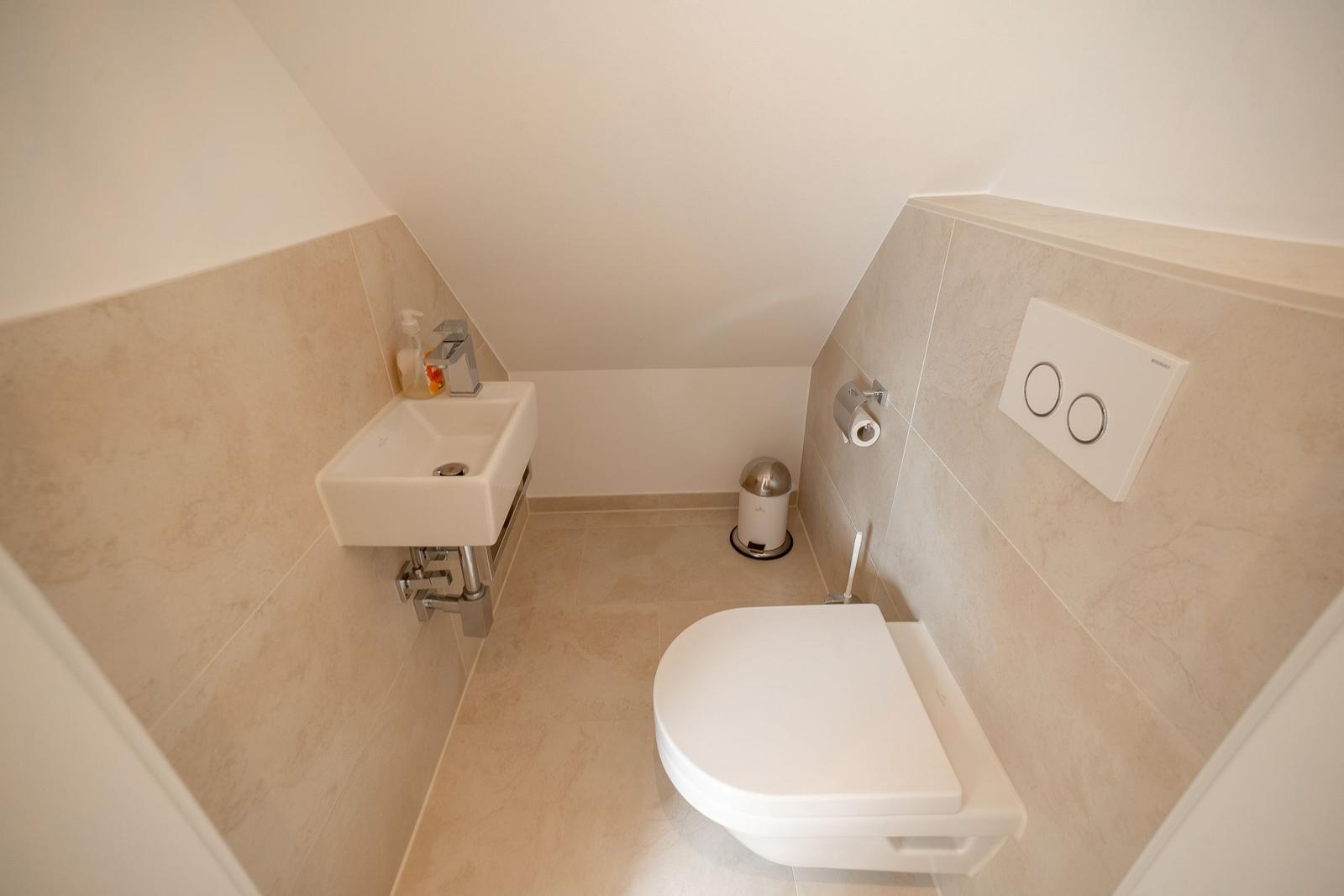 Dusche mit Toilette und Waschbecken unter Dachschrägen