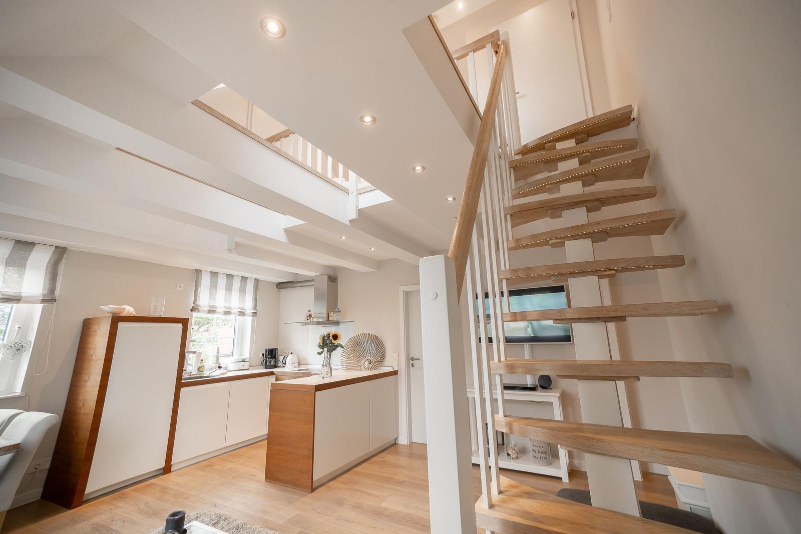 Moderne Küche mit Holzoptik und Treppe zur oberen Etage.