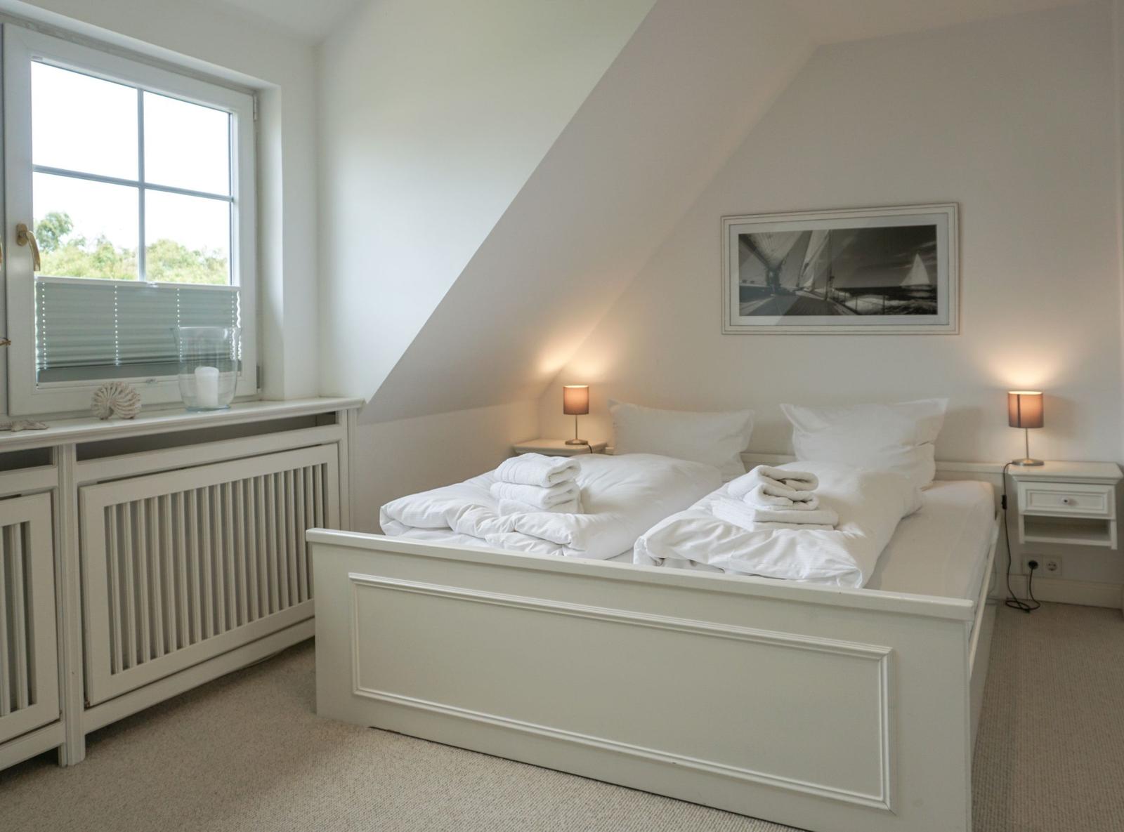 Bedroom with double bed, window, and nightstands.