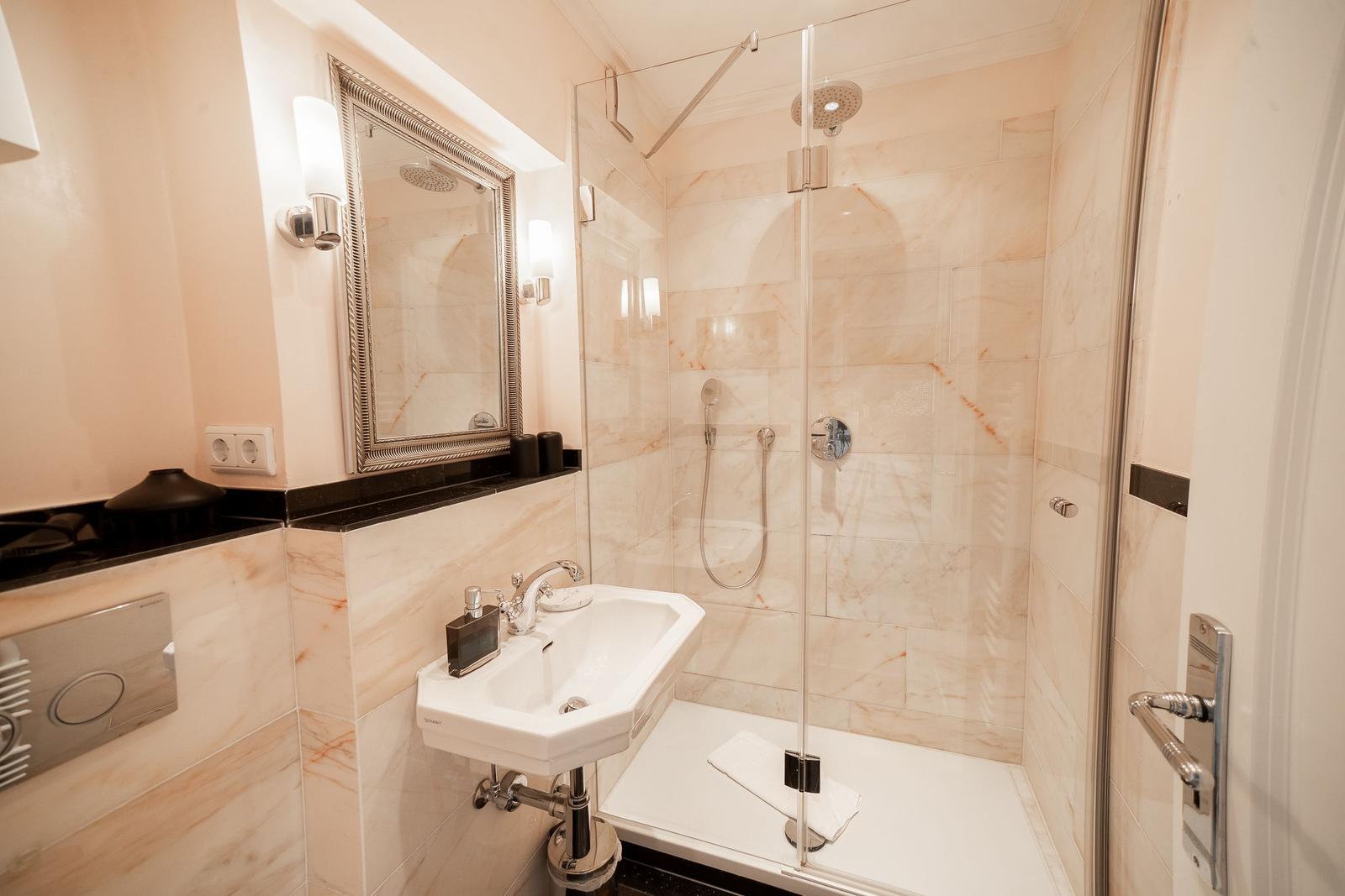 Bathroom with shower, sink, and mirror